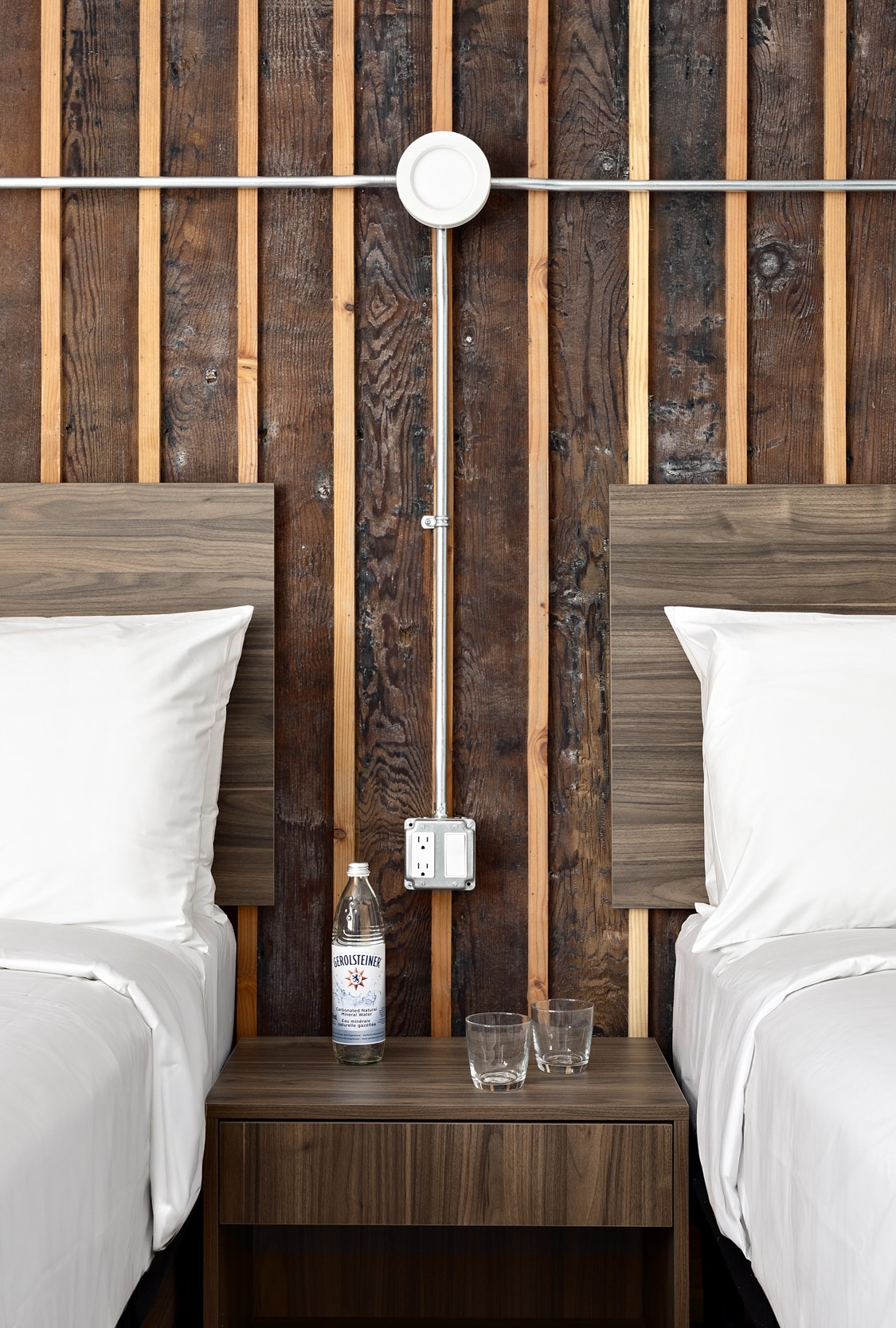 Hotel room — queen bed in foreground, windows looking out onto city