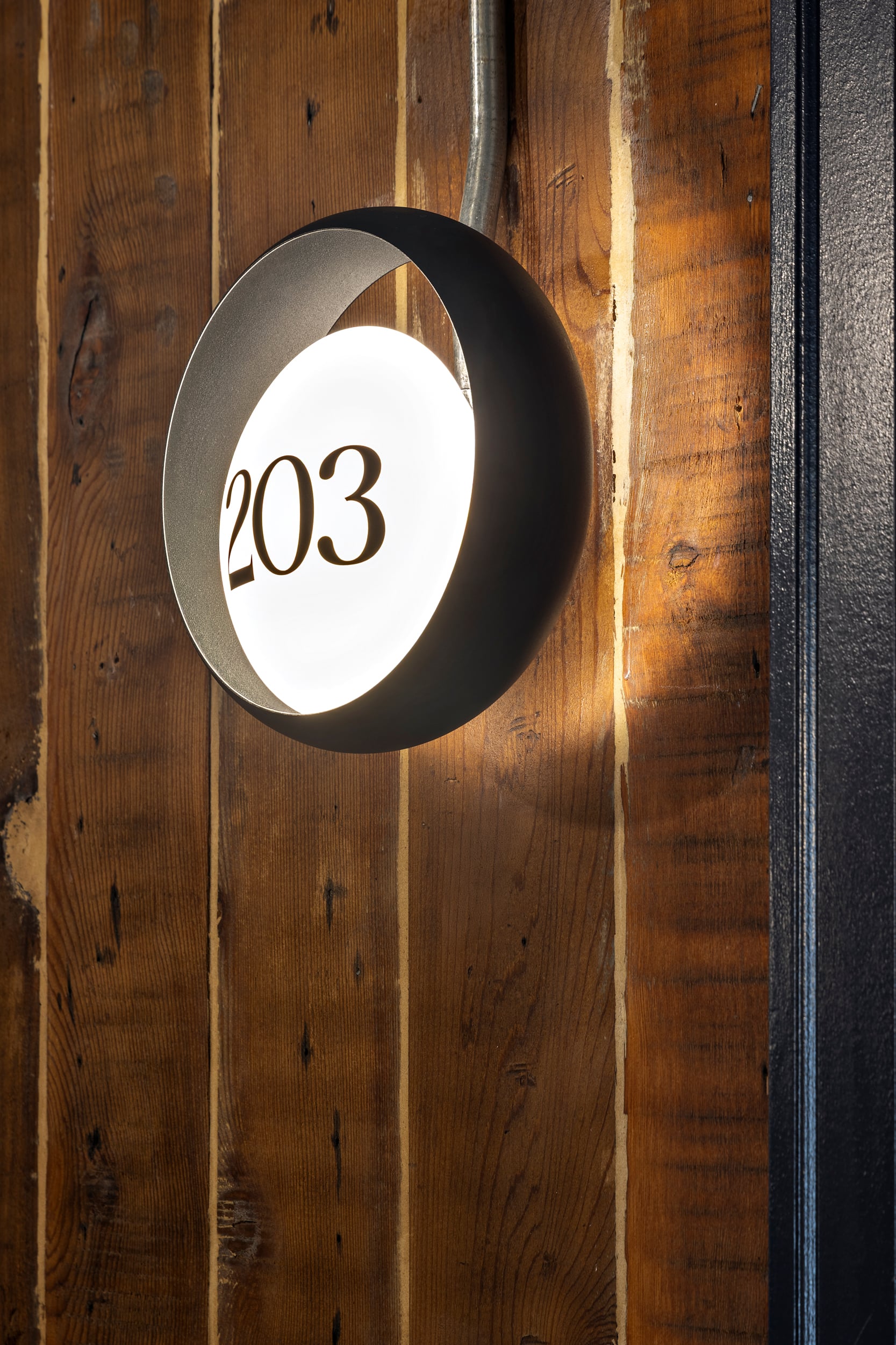 Room 203 sign mounted on original wood panelling at Hotel Modo
